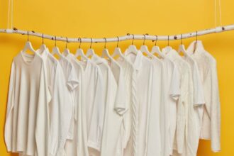 092797700 1650864208 Group White Plain Clothes Hanging Garment Rack Rail Minimalistic Concept Apparel Women Isolated Yellow Background
